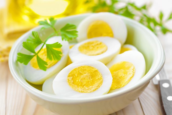 Отварные яйца в миске с зеленью
