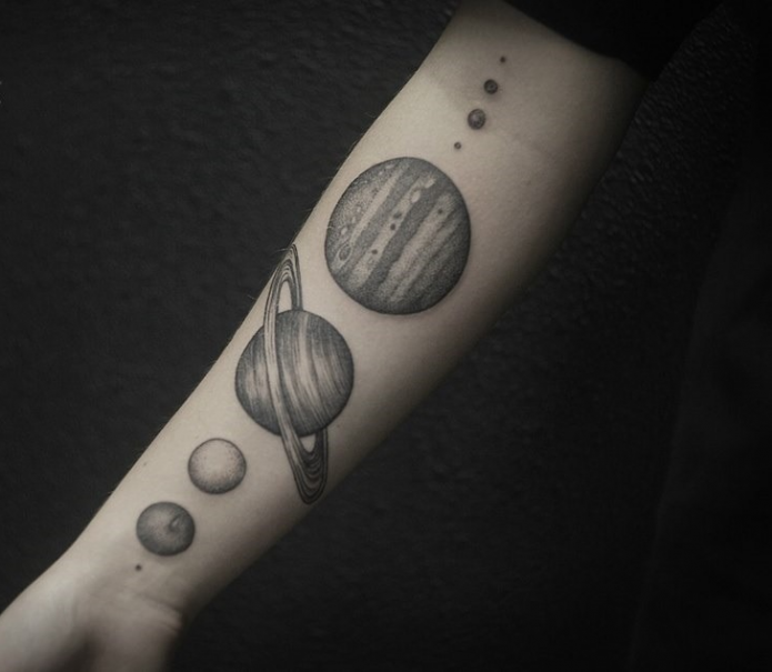 монохромная татуировка планеты на руке
