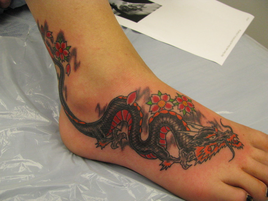женская татуировка с драконом на ноге.