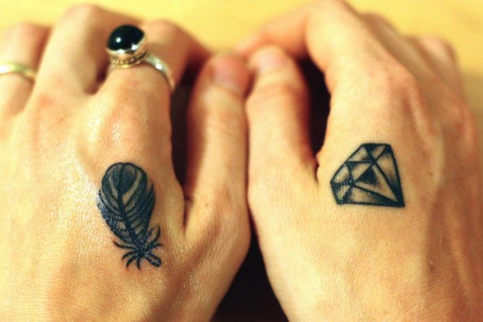 двойная татуировка на кистях рук перо и алмаз
