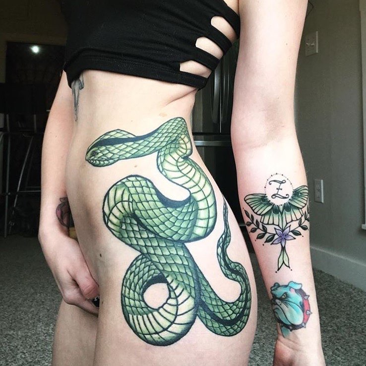 большая татуировка на бедре зелёная змея.