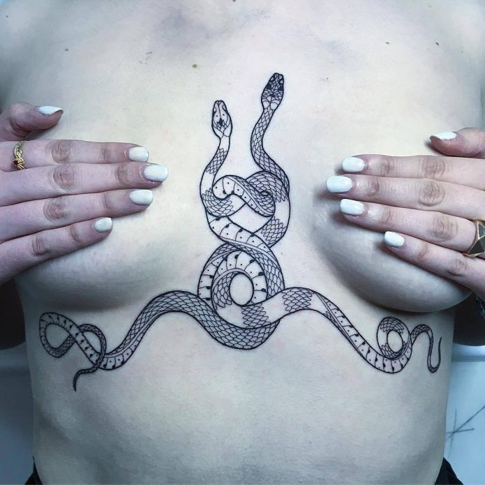 татуировка с переплетением змей на груди у девушек